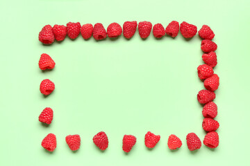 Frame made of fresh raspberries on green background