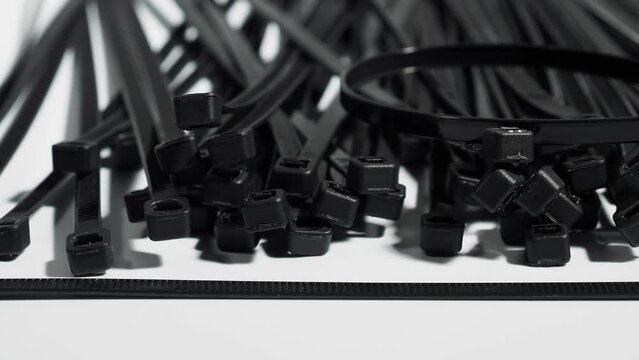Plastic black ties on a white background. Plastic ties for cables.