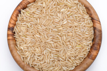 Suchy ryż brązowy o długich ziarnach w miseczce na białym tle