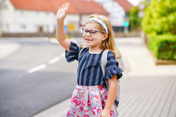 Little Preschool Girl on the Way to School. Healthy Happy Child Walking to Nursery School and Kindergarten. Smiling Child with Eyeglasses and Backpack on the City Street, Outdoors. Back to School.