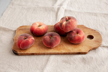 Organic Donut Saturn Peaches on a rustic wooden board, side view.