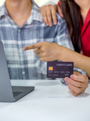 Young couple consumer hand holding mock up credit card, Ready to spend pay online shopping according to discount products via smartphone and laptop from home office