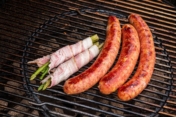 grilled sausages and bacon on grill