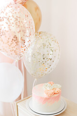 Birthday celebration for child girl at home light pink and gold colors. cake with flowers, balloons