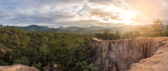 Evening sunset, orange light with a view of the sandy soil, forests and green mountains of the north at Pai Canyon, Thailand, a landmark of Mae Hong Son Province. and a beautiful sunset view