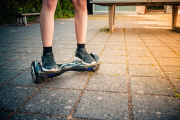 Teenager riding a hoverboard at schoolyard - self-balancing scooter, levitating board used for...