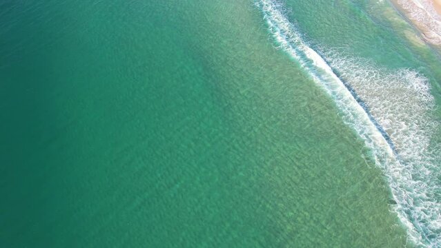 Turquoise Sea Waters With Waves Splashing At Kawana Beach In Queensland, Australia. aerial tilt-up