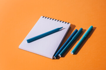 School supplies on orange backdrop. Back to school concept.
