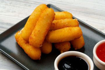 Fried snacks platter with sauce on gray wooden table