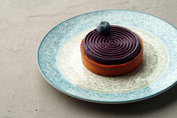 Fototapeta na wymiar Blueberry tart on the gray table close up