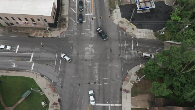 Intersection in downtown Elkhart, Indiana with traffic moving and drone video looking down stable.