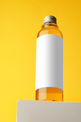 Bottle with skincare oil against yellow background