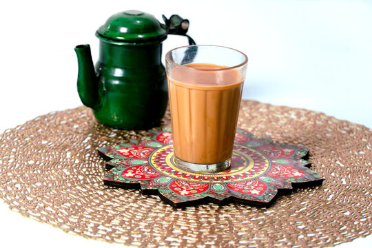 Fresh milk tea or indian karak chai in glass with chanak or masala tea in glass cup on textured background