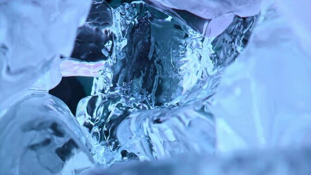 Extreme close up pov view on blue liquid is poured out in ice cubes on camera moves inside away of us. Slow motion 1000 fps water liquid is poured out in blue ice cubes. Super slow motion 1000 fps