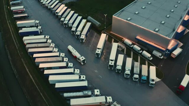 Tank truck riding on road to depot, distributing liquid aerial shot. Tanker lorry delivering fuel, driving to terminal warehouse parking in evening