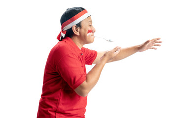 Indonesian men celebrate Indonesian independence day on 17 August with a marbles race using a spoon