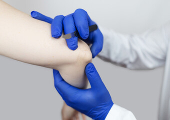 Elbow surgery. Surgeon shows the patient where the incision will be with scalpel for operation due...