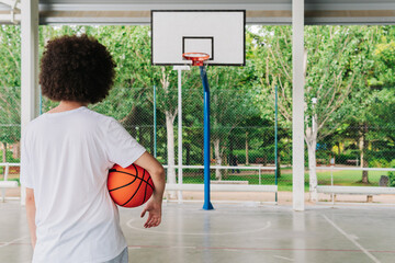 Rear view of a basketball player looking at the basket