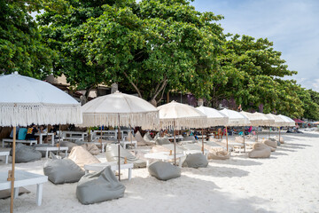 Beaches in Thailand with beach chairs and umbrellas for tourists to relax.