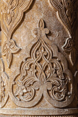 Floral ornament. Carving on wooden column in the Juma Mosque. Close up fragment, vertical, selected focus. Khiva (Xiva), Uzbekistan