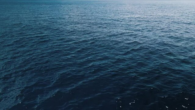 Camera flies over the tropical sea and tilts down