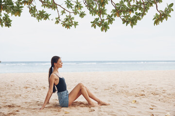 Fototapeta na wymiar woman smile nature sea vacation sand sitting travel carefree beach freedom