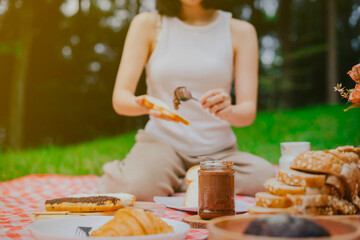 close up chocolate jam with blur background woman is spreading chocolate jam to bread
