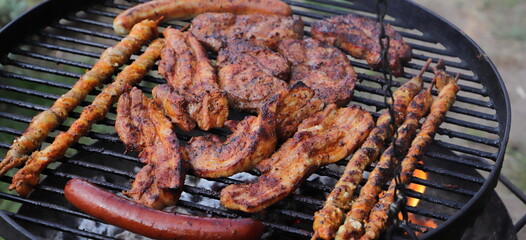 various meat and sausages on the charcoal grill