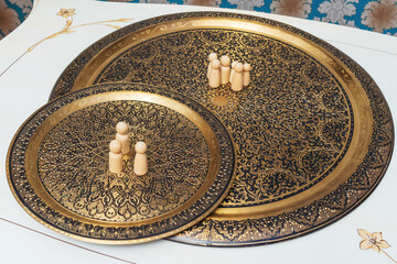 wooden figurines of people on the table. subject photo session of humanoid toys in the room. wooden toys on a bronze plate