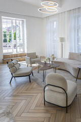 creative coffee table and fashionable upholstered furniture in the living room in a spacious open-plan apartment with a stylish modern bright design on a sunny day