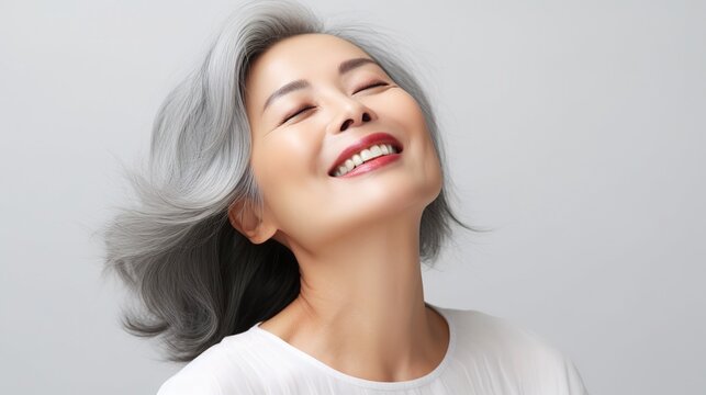 portrait of gorgeous happy joyful middle aged mature cheerful asian woman, senior older 50s gray haired lady eyes closed isolated on white. Ads of replenishing antiaging skin and hair care, generative