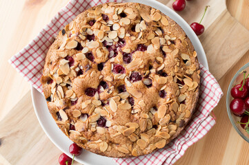 Homemade cherry pie with almonds and sour cherries on a wooden table