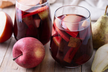 Autumn sangria with pear and apple on wooden table