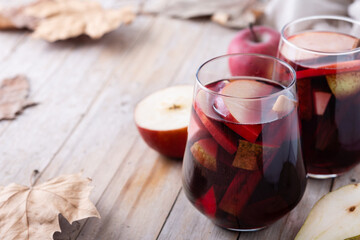 Autumn sangria with pear and apple on wooden table. Copy space