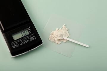Measuring spoon and Guar gum powder or guaran. Food additive E412. Accurate electronic digital scale. Thickening agent. Guar Gum widely used in food industry and cosmetics