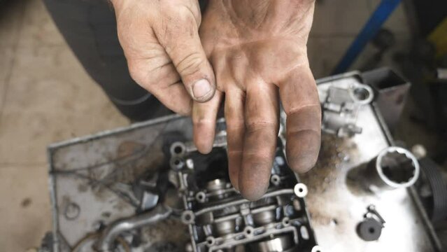 POV male dirty hands of young mechanic at workshop. Repairman rubbing unclean arms from fuel oil after hard work at garage. Concept of maintenance service. Slow motion