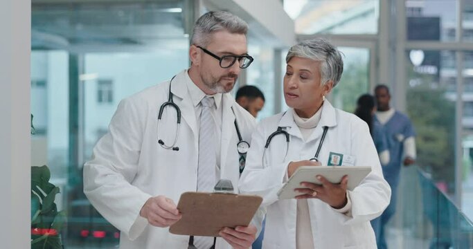 Teamwork, documents or senior doctors in a discussion for medical or healthcare feedback, review or results. Talking, teamwork or mature leader in conversation with nursing worker meeting in hospital