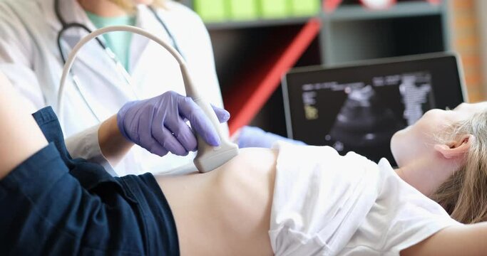 Doctor with a probe on the child's stomach close-up. Ultrasound of the abdominal organs, pediatrics