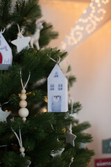 Christmas tree decorated with toys and garlands in the form of houses