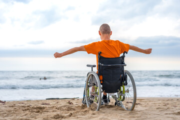 Fototapeta premium A disabled person on his back in a wheelchair on the beach