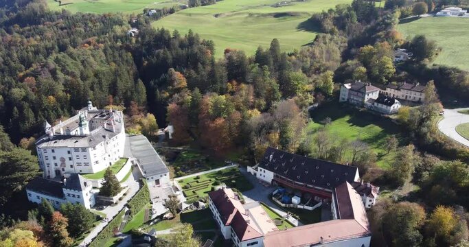 Ambras castle in a vertical aerial view on an autumn day and with its green forests and the tranquility of this place in Tyrol in Austria
