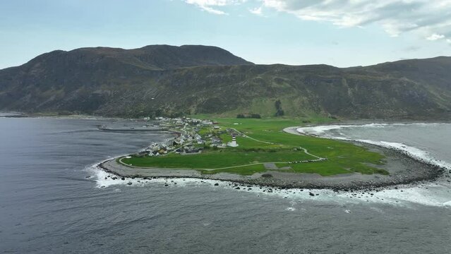 Alnes lighthouse on peninsula covered by Atlantic ocean outside Alesund Norway - Aerial from seaside looking towards lighthouse and shoreline