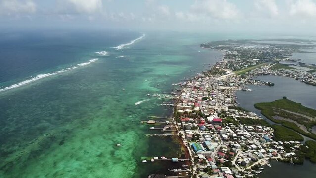 Aerial view of the city of San Pedro, Belize and the clear ocean, drone tilt forward