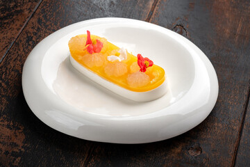 Jelly cake dessert with fruit marmalade and yogurt mousse on a white plate