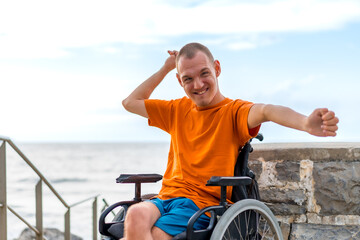 Portrait of a very cheerful disabled person in a wheelchair at the beach on vacation