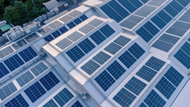 Aerial view of solar roof of the factory in eco environment. Solar Cells panel reflection with the sun and turn to blue color in industrial area. Concept of energy recycle.