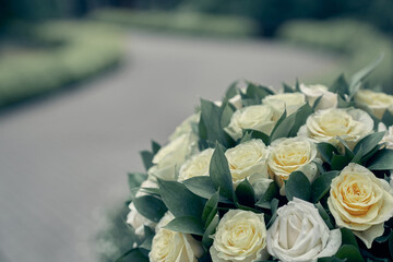 White roses on a blurry road background. Flower arrangement, bouquet of garden flowers. It can be used for invitations, greetings, wedding cards. High quality photo