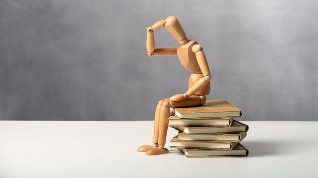 Denker auf Buchstapel