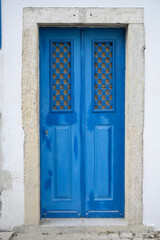 Front view of old blue wooden door with frosted glass window