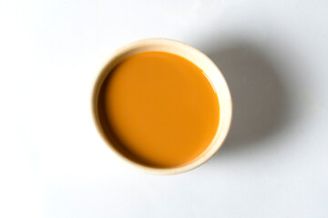 Fresh milk tea or indian karak chai in payali or masala tea in clay cup on white background. top view